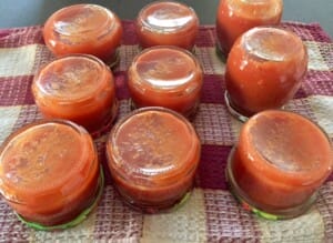 Napełnianie słoików Ketchup z cukinii z papryką przelany do słoików