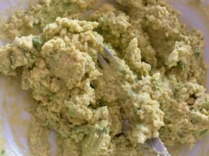 Mieszanie pasty z żółtkiem i awokado guacamole z jajkiem wymieszane ze szczypiorkiem