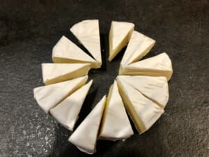 camembert w panierce pokrojony na trójkąty przed smażeniem