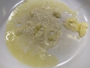 Smażenie czosnku na maśle do zupy czosnkowej z grzankami