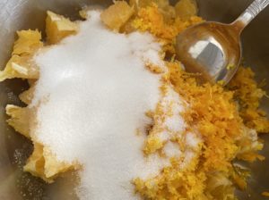 Składniki na mus pomarańczowy w garnku pomarańcze z cukrem i cytryną na mus do mazurków z białą czekoladą