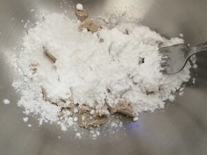 Drożdże wymieszane z cukrem pudrem Drożdże przygotowane do wyrabiania zawijańca z makiem i kruszonką