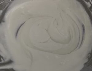 Mieszanie śmietanki z galaretką Łączenie ubitej śmietanki z galaretką do ciasta shrek z bananami
