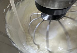 Dodawanie śmietanki do kremowego sernika w czekoladzie