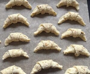 Gotowe, uformowane rogaliki ułożone na blasze wyłożonej papierem do pieczenia